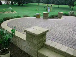 A brick patio with stone steps and benches.