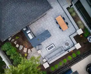 A patio with an outdoor kitchen, table and chairs and a firepit.