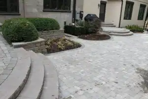 A stone patio with steps leading to a house.
