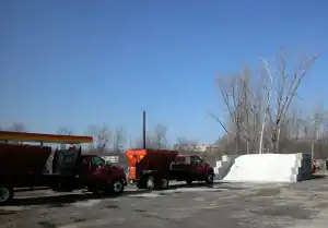 A yellow and red construction vehicle parked in a parking lot.
