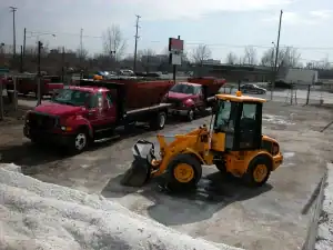 A yellow and red construction vehicle parked in a parking lot.