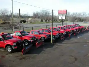 Snow removal trucks lined up in the parking lot.
