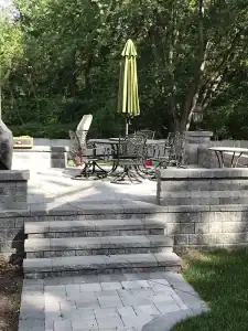 Gray block steps leading up to patio with outdoor patio.