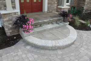 Entryway and steps paved with gray blocks and stone.