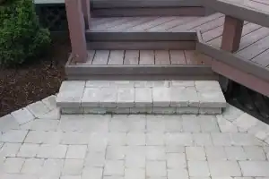 Paved steps leading up to wooden deck.