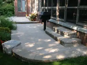 Block steps, outdoor barbeque and patio with plants.