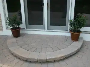 Curved block steps with potted plants on either side.