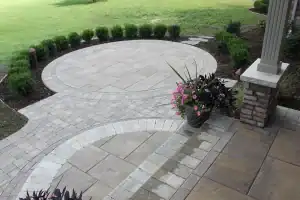 Outdoor stone patio with landscaped garden and decorative potted plants.