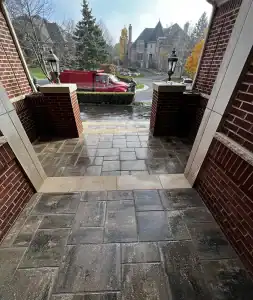 Front porch with brick columns and stone flooring, showcasing outdoor home improvement.