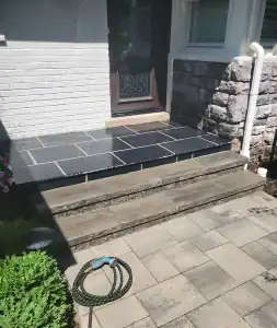 Block steps and black tile paved porch.