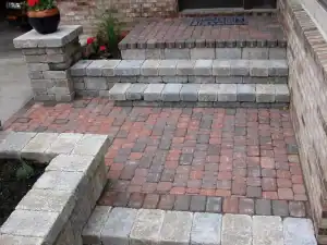 Beautiful stone paved outdoor entrance with steps and garden borders.