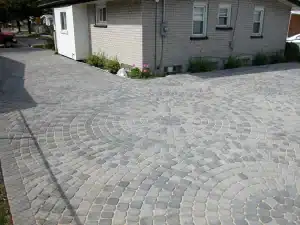 Beautifully designed stone driveway with circular patterns in gray tones.