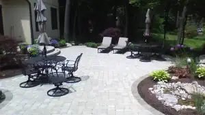 Beautiful outdoor patio with tables, chairs, and umbrellas in a lush garden setting.