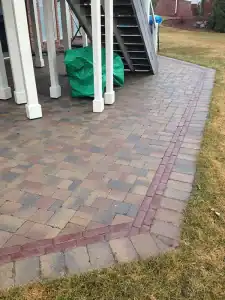 Outdoor paver patio with edging and stairs.