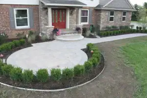 Beautiful paved front yard with landscaping and shrubbery in a residential garden.