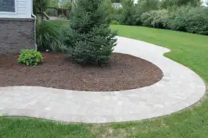 Outdoor stone pathway in a landscaped garden with trees and grass for aesthetic appeal.