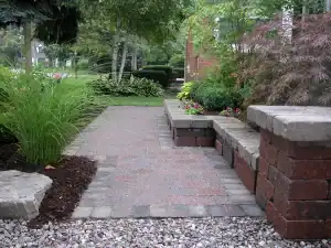 Outdoor garden pathway with brick borders and lush greenery.
