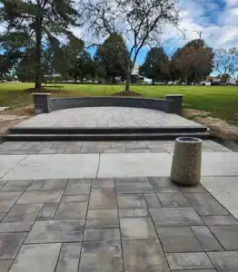 Outdoor patio with stone paving and landscaped surroundings.