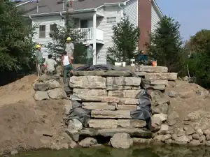Retaining wall construction with natural stone for outdoor landscaping and garden enhancement.