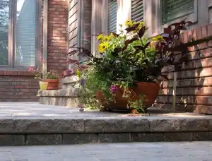 Flower pot with colorful plants on brick porch in San Marino.