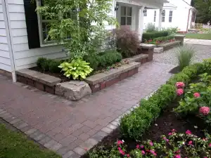 Beautiful landscaped garden with brick-paved walkway and vibrant plants.