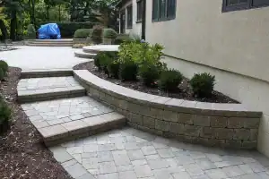 Curved paved steps with retaining wall for plant bed.