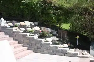 Stone steps with block retaining wall and tiered garden.